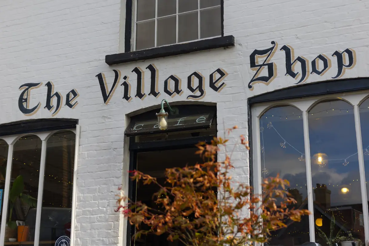 The Village Shop's traditional painted sign above the café entrance