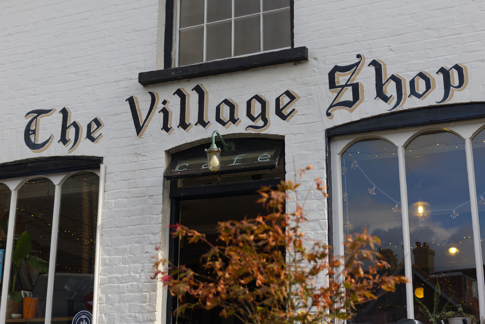 The Village Shop's traditional painted sign above the café entrance
